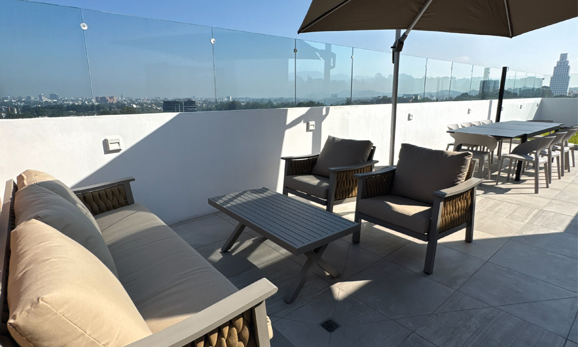 Sala de estar exterior del rooftop de PRIVE con vista a la ciudad
