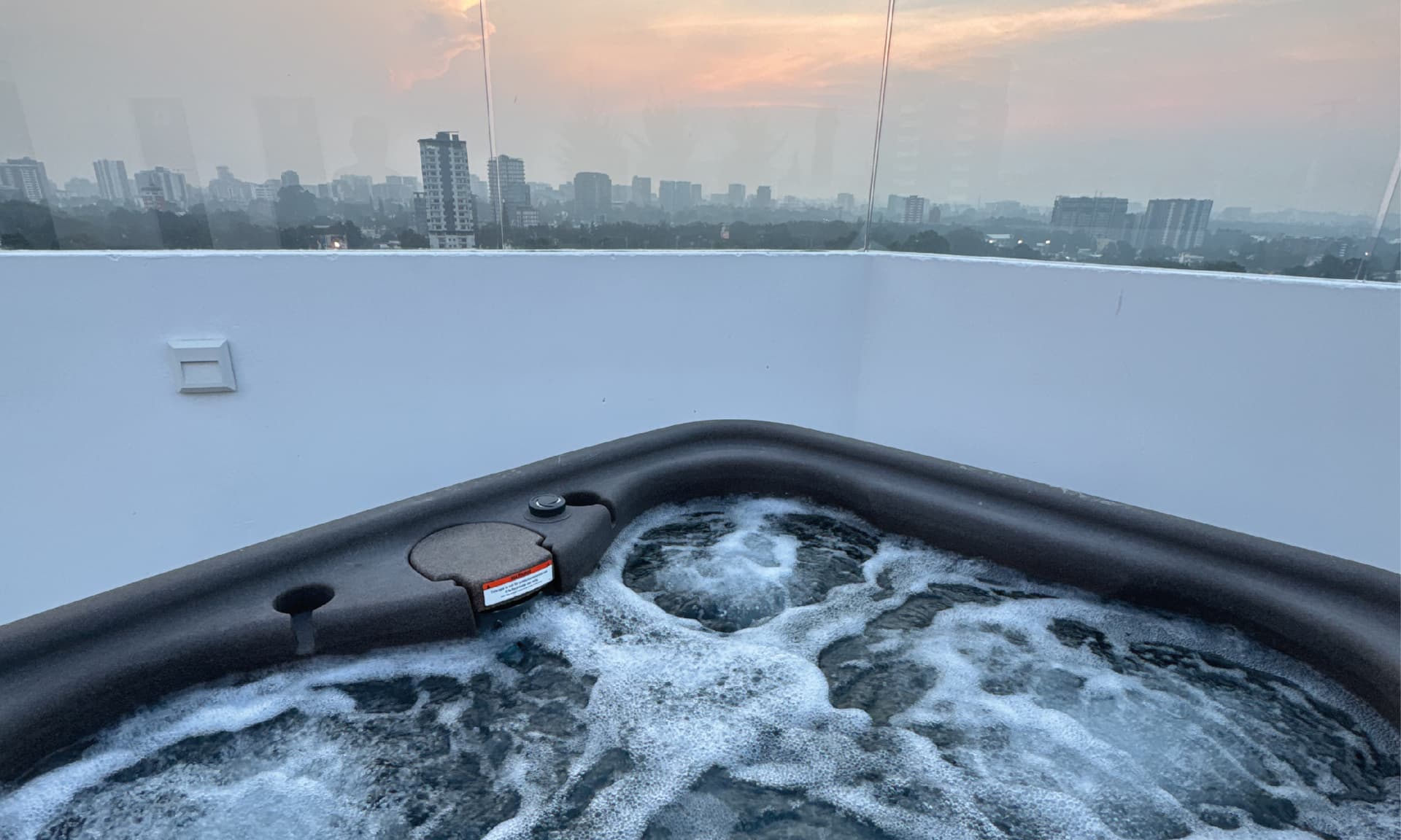 Jacuzzi del rooftop de PRIVE con vista a la ciudad al atardecer
